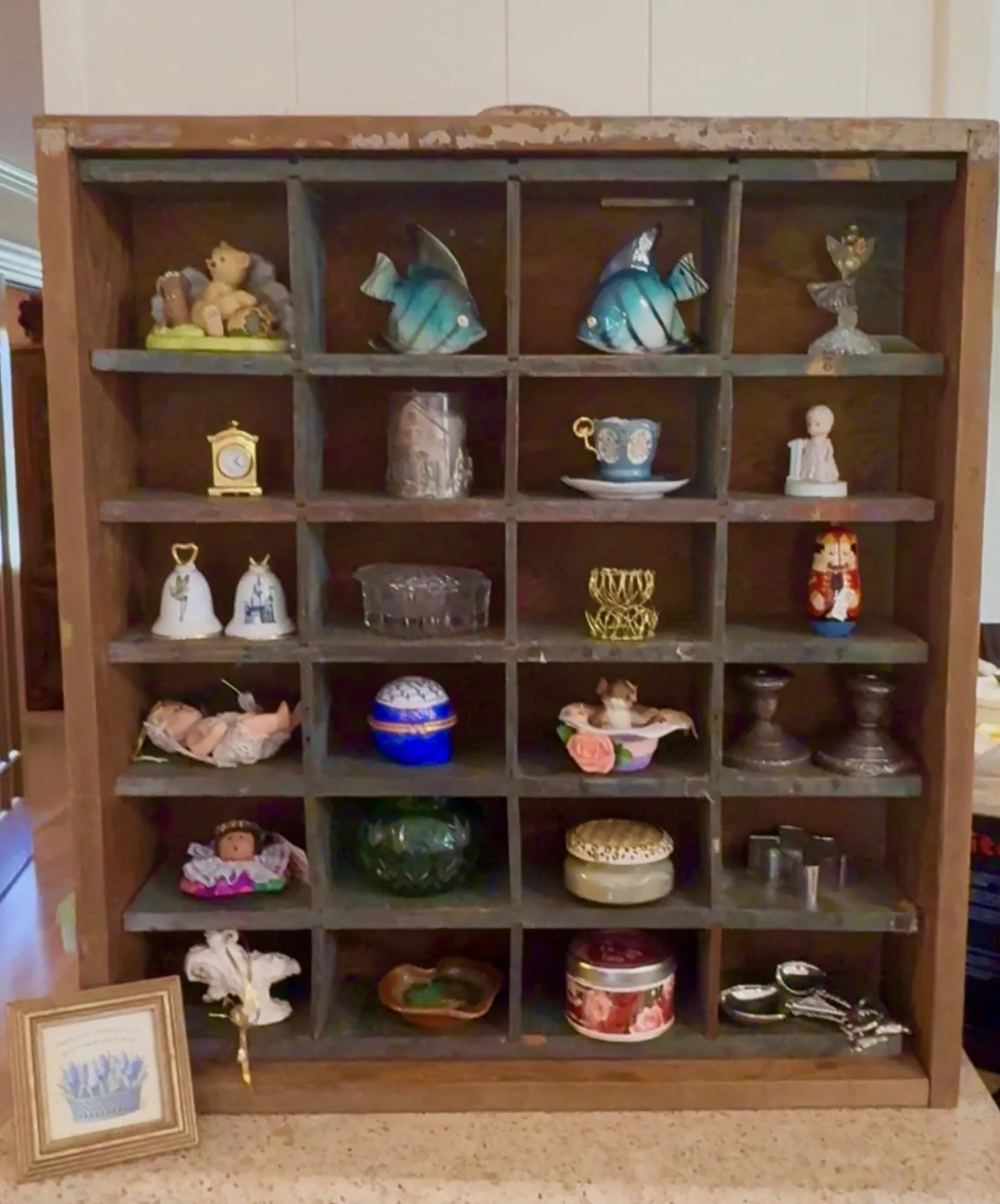 Small vintage collectibles arranged in a wooden cubby display