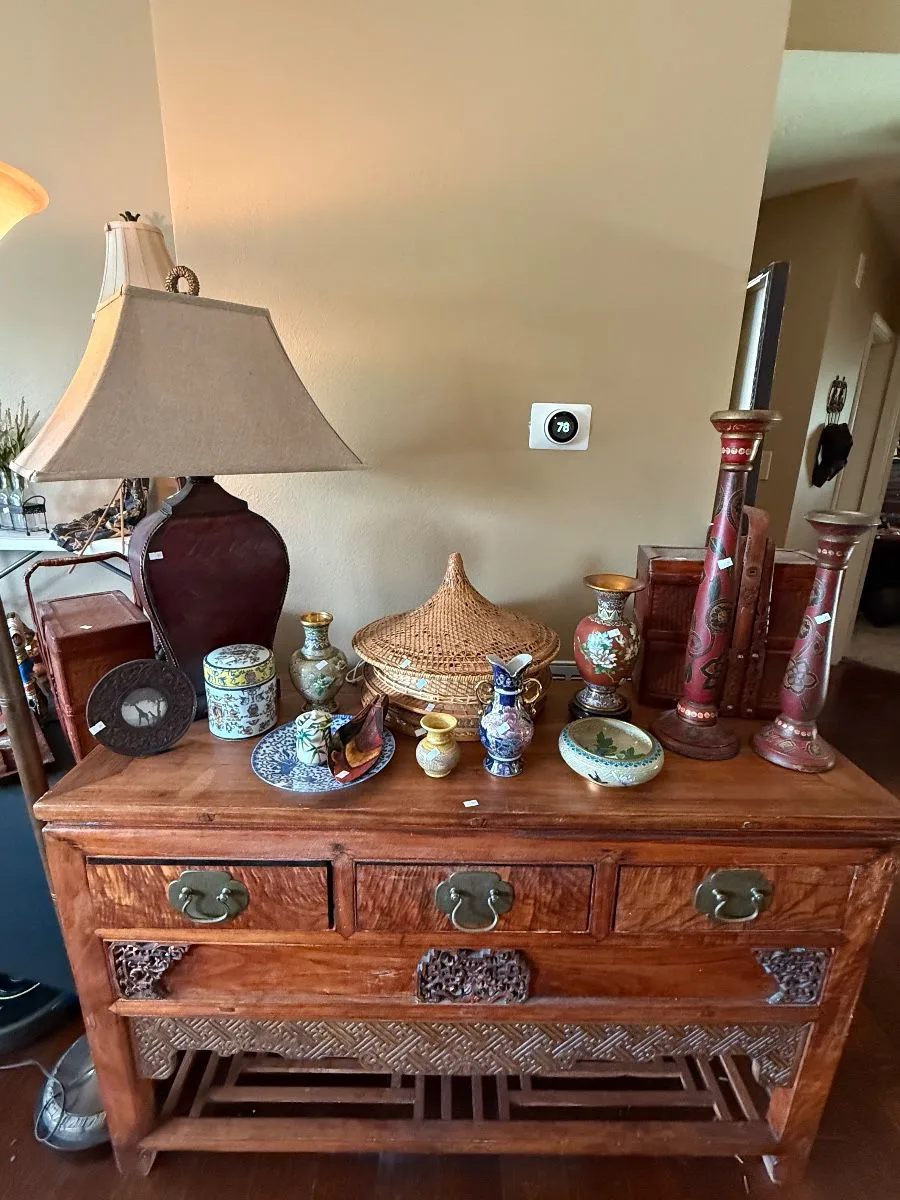 Asian ceramics, baskets, and decor arranged on a carved wood table