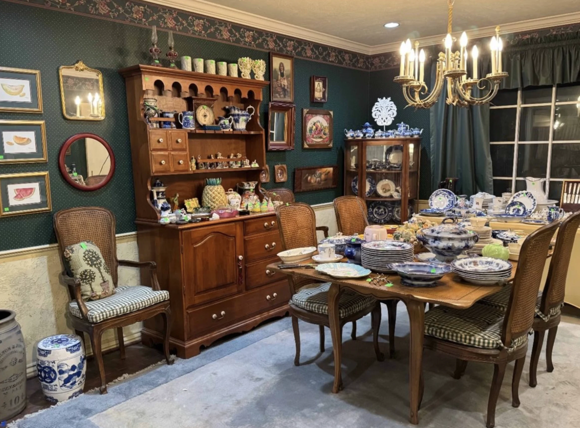 A dining room filled with wooden furniture and blue-and-white tableware prepared for a J and M estate sale