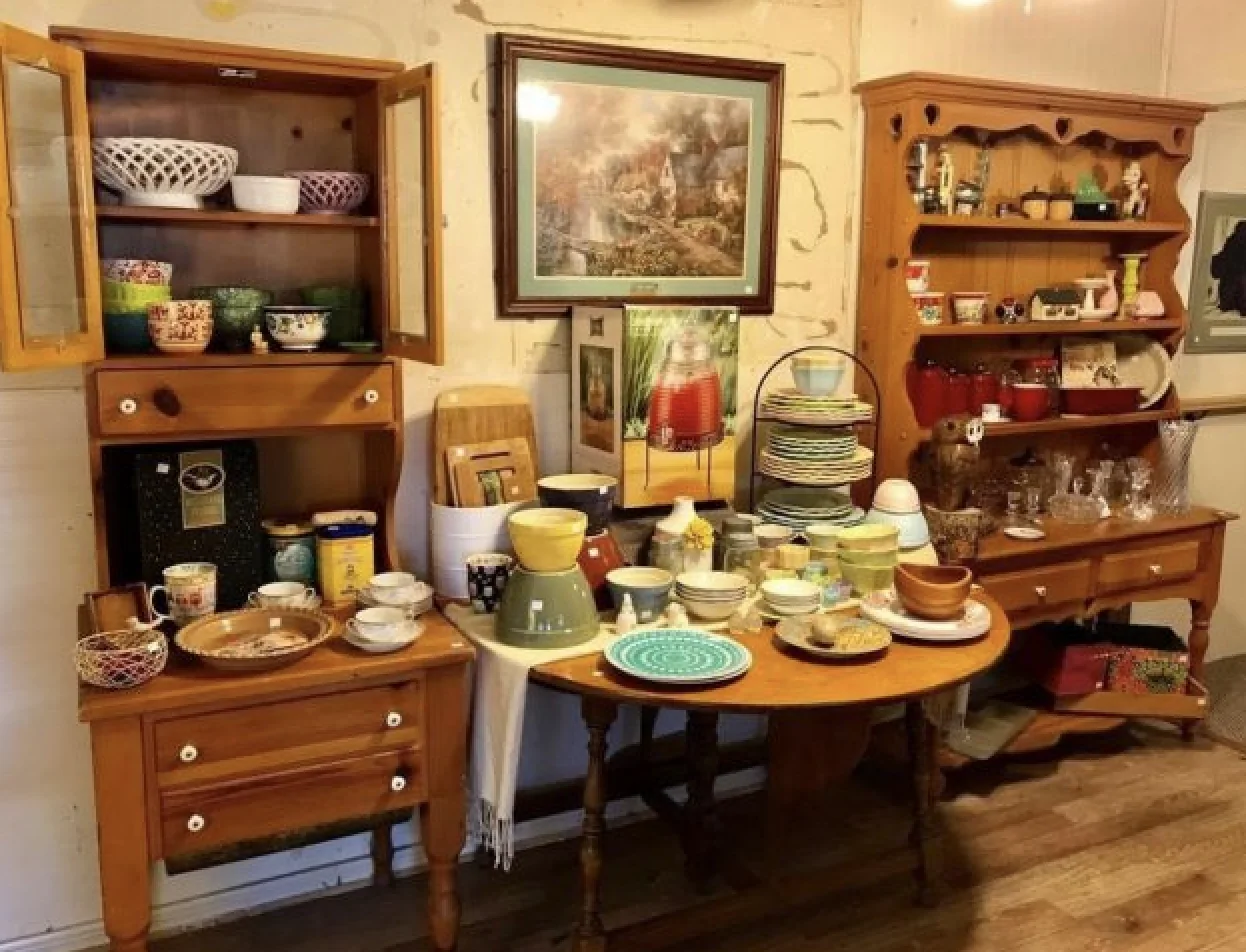 Wooden furniture and colorful tableware arranged for a J and M estate sale