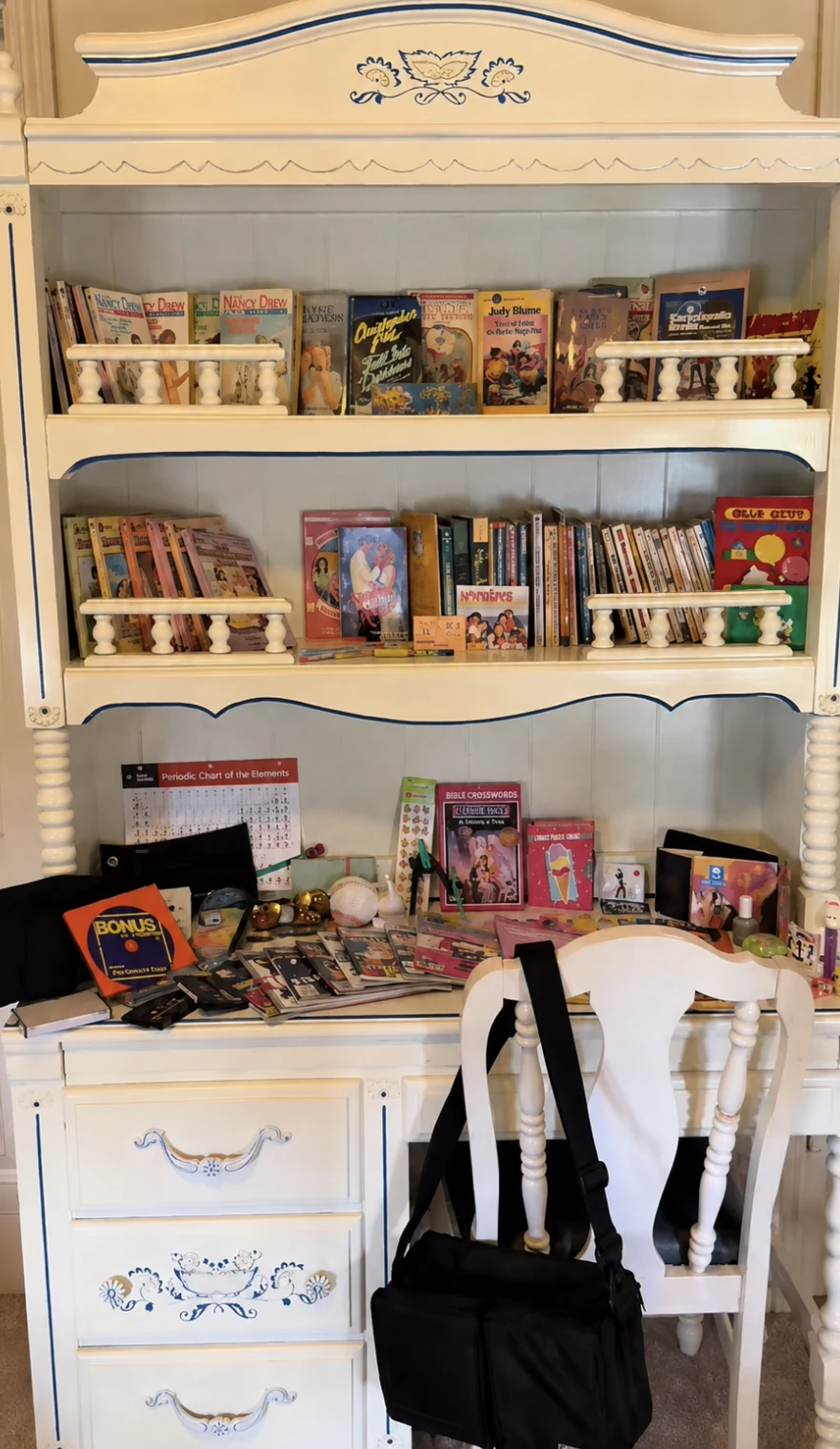Vintage books, games, and magazines arranged on a white desk for a J and M estate sale